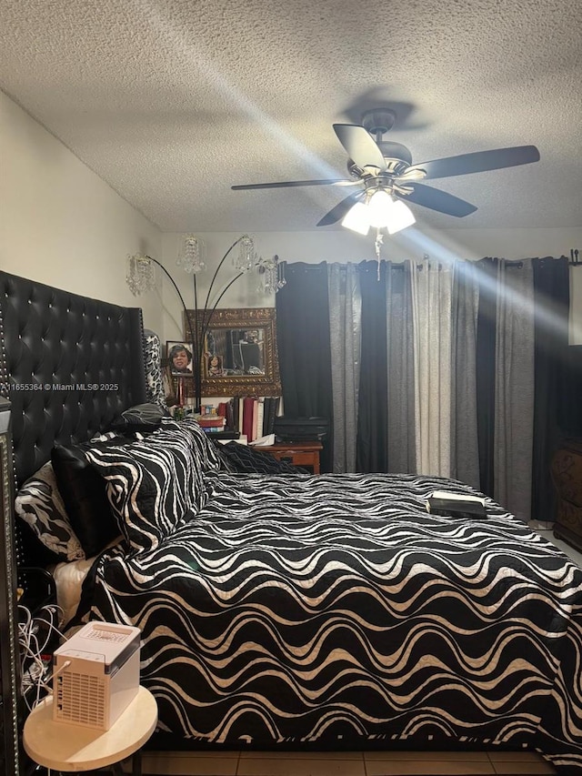 bedroom with tile patterned flooring, a textured ceiling, and ceiling fan