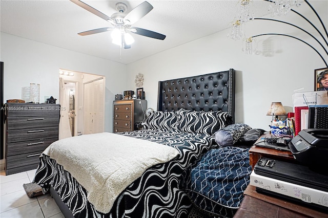 tiled bedroom featuring a textured ceiling, ceiling fan, and a closet