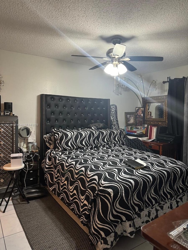 tiled bedroom featuring ceiling fan and a textured ceiling