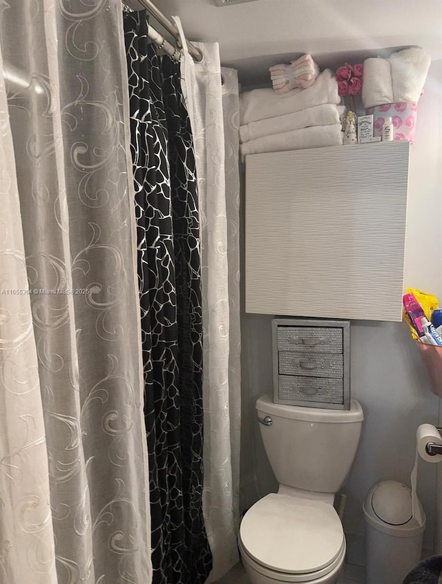 bathroom with a shower with curtain and toilet