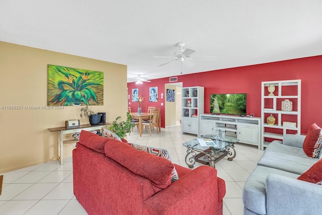 living room featuring ceiling fan, light tile patterned flooring, and a textured ceiling