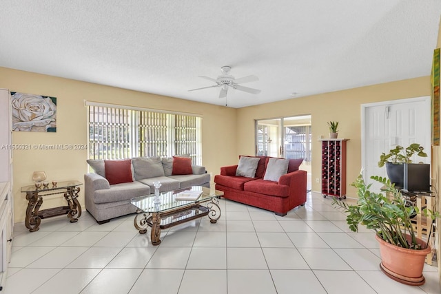 tiled living room with a textured ceiling and ceiling fan