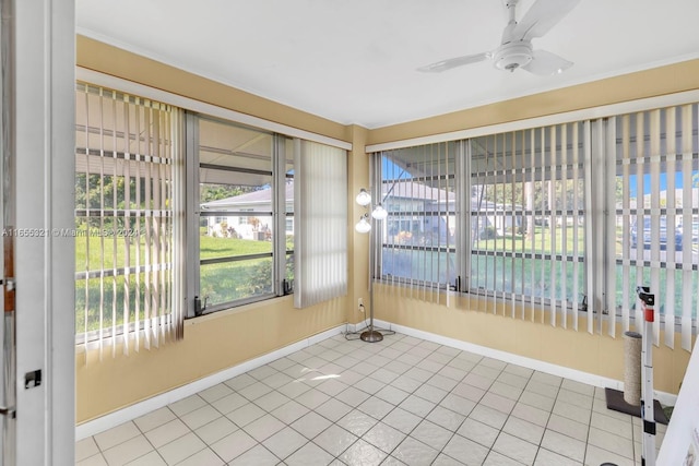 unfurnished sunroom featuring ceiling fan