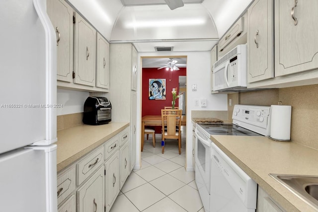 kitchen with light tile patterned floors, white appliances, sink, and ceiling fan