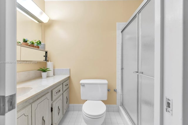 bathroom featuring vanity, tile patterned floors, an enclosed shower, and toilet