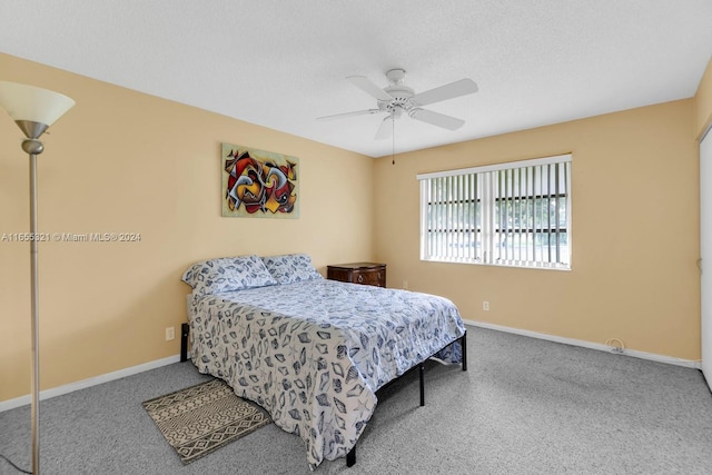 carpeted bedroom with ceiling fan and a textured ceiling