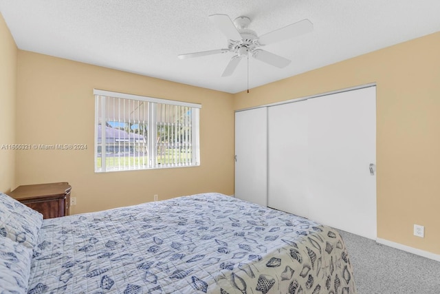 bedroom featuring a textured ceiling, carpet flooring, ceiling fan, and a closet