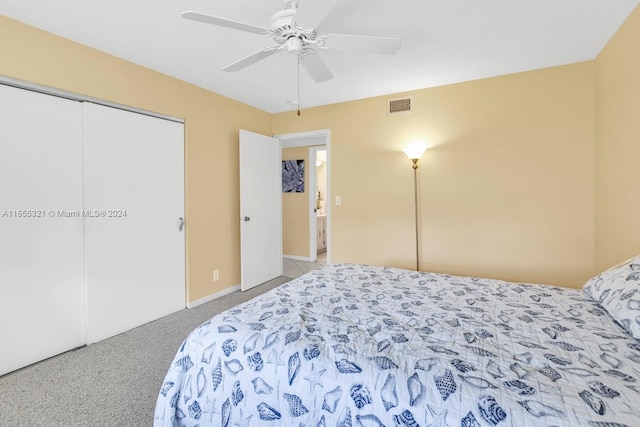 bedroom with ceiling fan, light colored carpet, and a closet