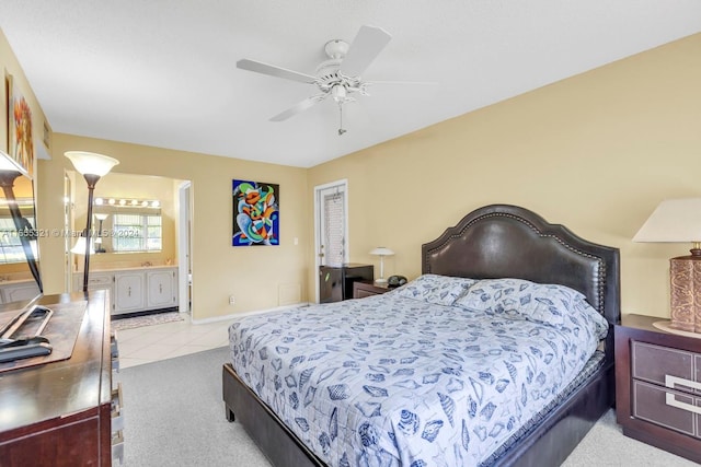 bedroom with ceiling fan, light colored carpet, and ensuite bathroom