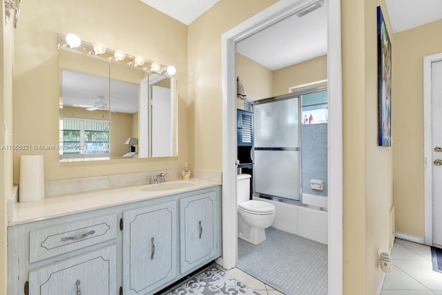 full bathroom featuring enclosed tub / shower combo, ceiling fan, vanity, toilet, and tile patterned flooring