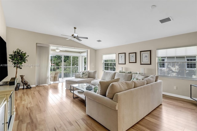 living area with lofted ceiling, light wood-style floors, baseboards, and visible vents