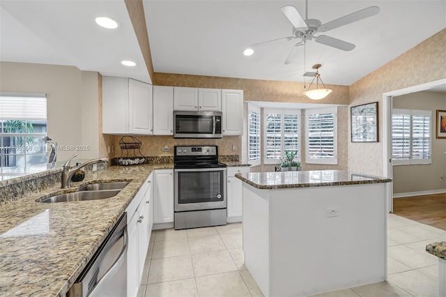 kitchen featuring appliances with stainless steel finishes, plenty of natural light, light tile patterned flooring, and a sink