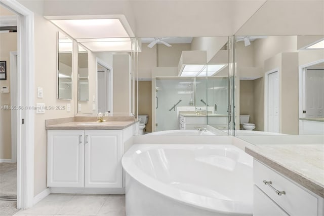 bathroom with toilet, ceiling fan, two vanities, tile patterned floors, and a bath