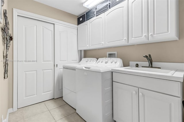 laundry room with cabinet space, light tile patterned flooring, a sink, and independent washer and dryer