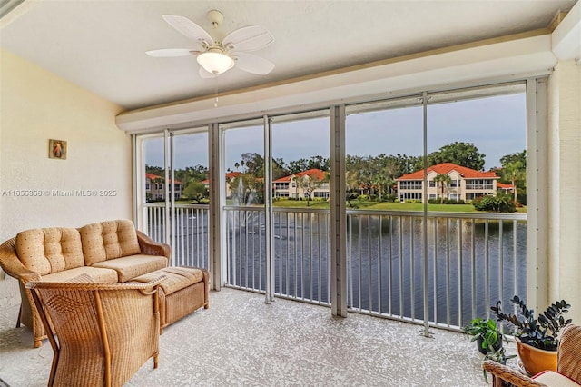 interior space featuring a water view, a wealth of natural light, and a ceiling fan