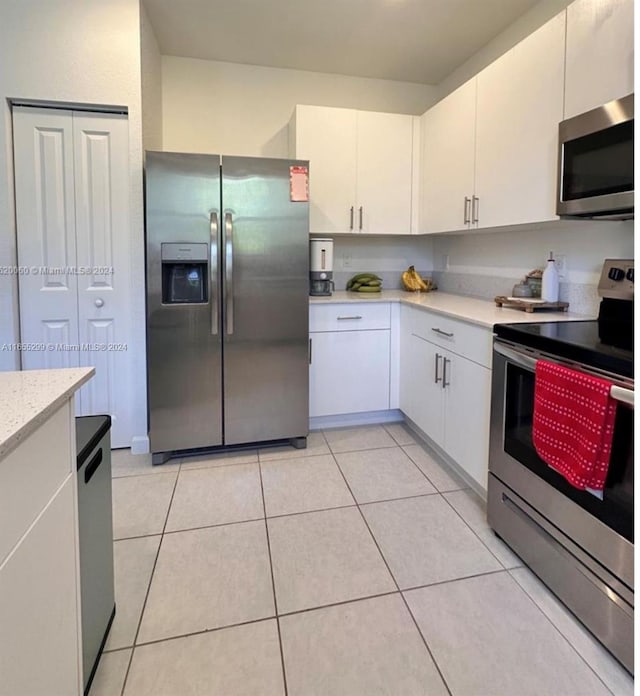 kitchen featuring light tile patterned floors, white cabinetry, and stainless steel appliances