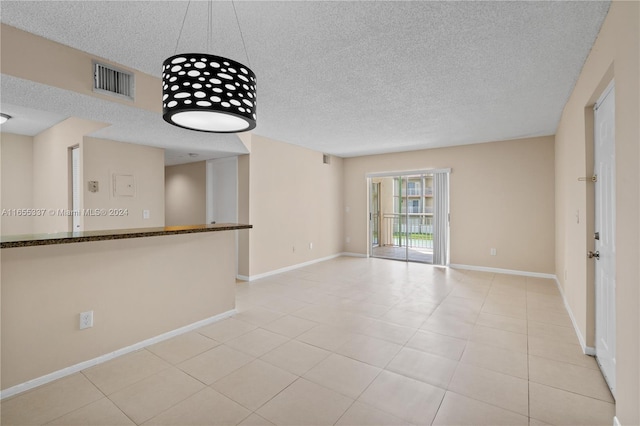 tiled spare room featuring a textured ceiling