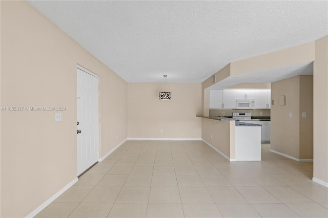 interior space with a textured ceiling and light tile patterned floors