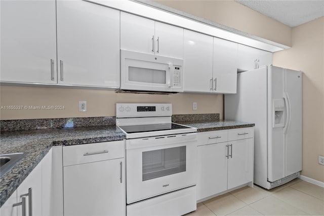 kitchen featuring white appliances, light tile patterned floors, and white cabinetry