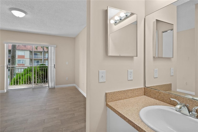 bathroom featuring vanity, a textured ceiling, and wood-type flooring