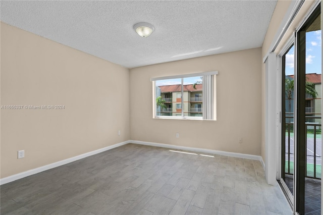 spare room featuring a textured ceiling and wood-type flooring