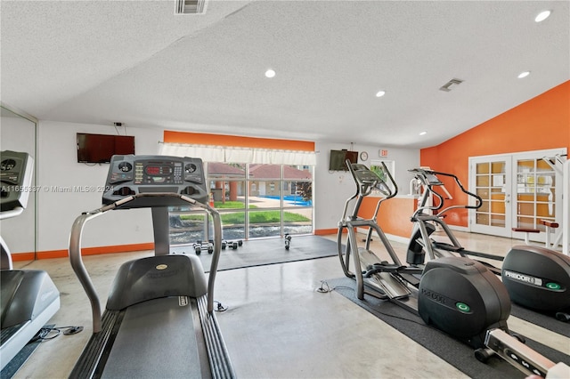 workout room featuring a textured ceiling, vaulted ceiling, and french doors