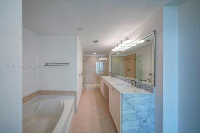 bathroom with tile patterned floors, vanity, and shower with separate bathtub