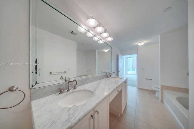 bathroom with tile patterned flooring, vanity, toilet, and a tub