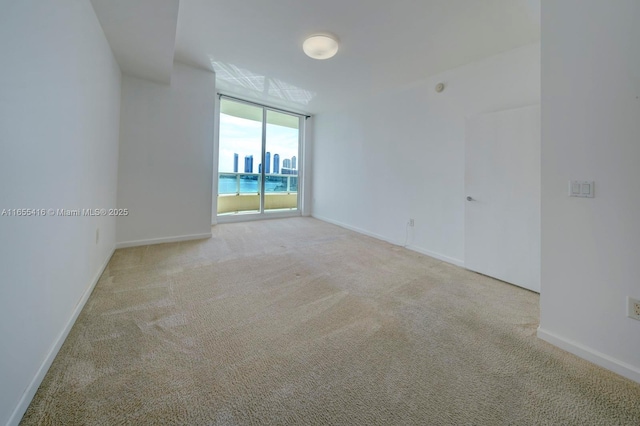 unfurnished room with floor to ceiling windows and light carpet