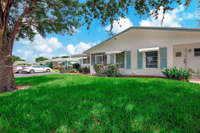 single story home featuring a front yard and brick siding