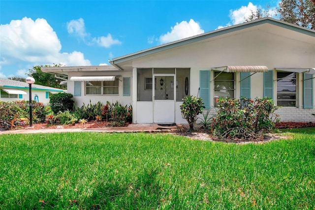 ranch-style house featuring stucco siding and a front lawn