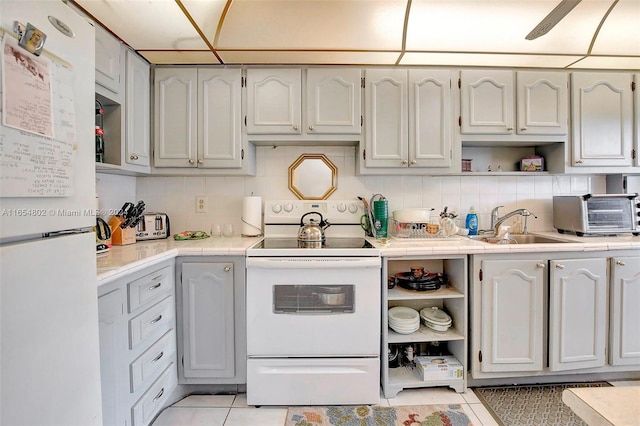 kitchen featuring open shelves, a toaster, light tile patterned flooring, white appliances, and a sink