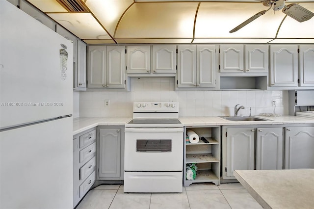 kitchen with white appliances, a sink, a ceiling fan, and backsplash
