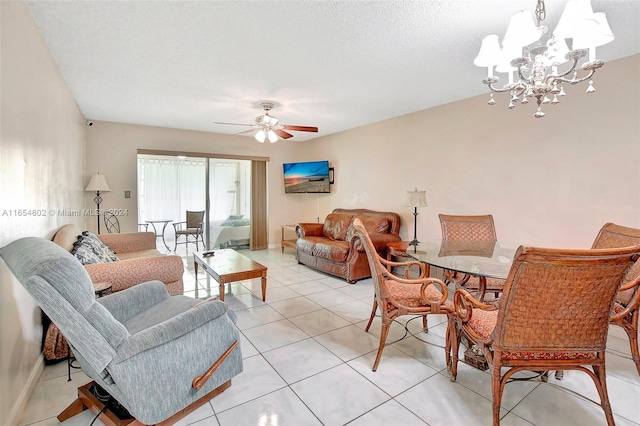 living area with light tile patterned flooring, ceiling fan with notable chandelier, a textured ceiling, and baseboards