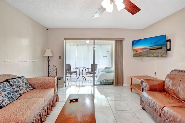 tiled living area featuring a ceiling fan, baseboards, and a textured ceiling