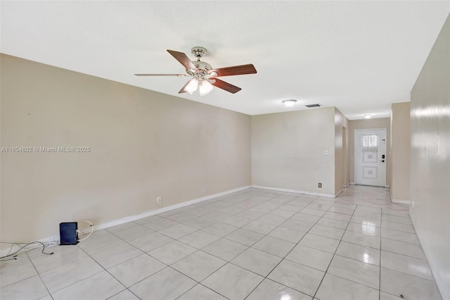 unfurnished room featuring ceiling fan, light tile patterned flooring, and baseboards