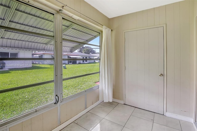 doorway to outside featuring tile patterned flooring and baseboards