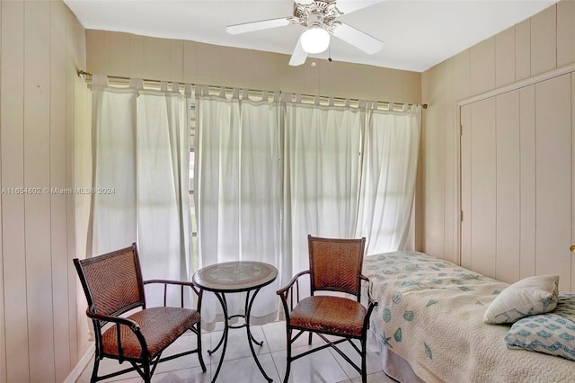 bedroom with wooden walls and ceiling fan