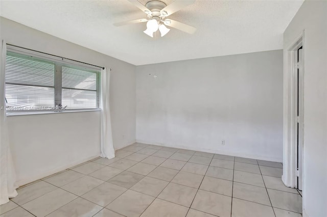 spare room with ceiling fan and light tile patterned flooring