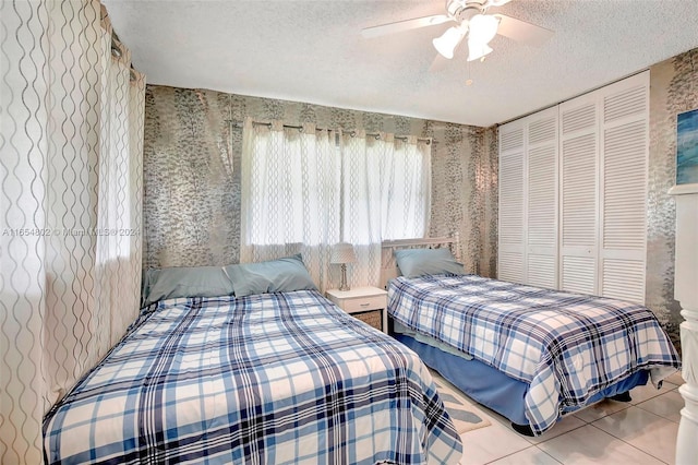 bedroom with a textured ceiling, ceiling fan, tile patterned flooring, and wallpapered walls