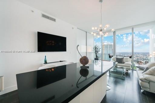 living room with a wall of windows and an inviting chandelier