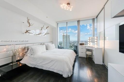 bedroom featuring dark wood-type flooring and expansive windows