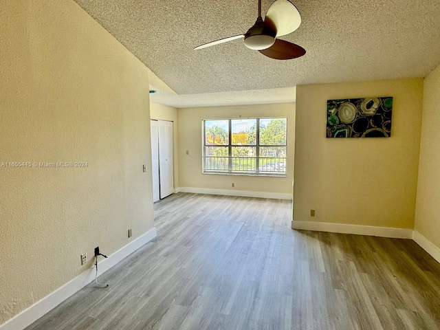 spare room featuring ceiling fan, a textured ceiling, and light wood-type flooring