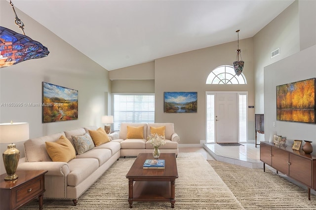 living room featuring high vaulted ceiling and light carpet