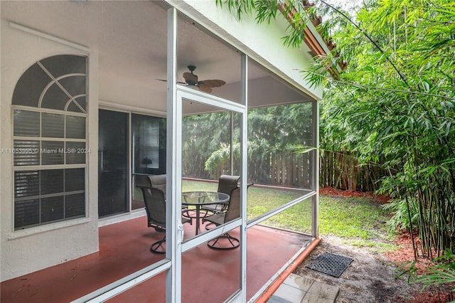 unfurnished sunroom featuring ceiling fan