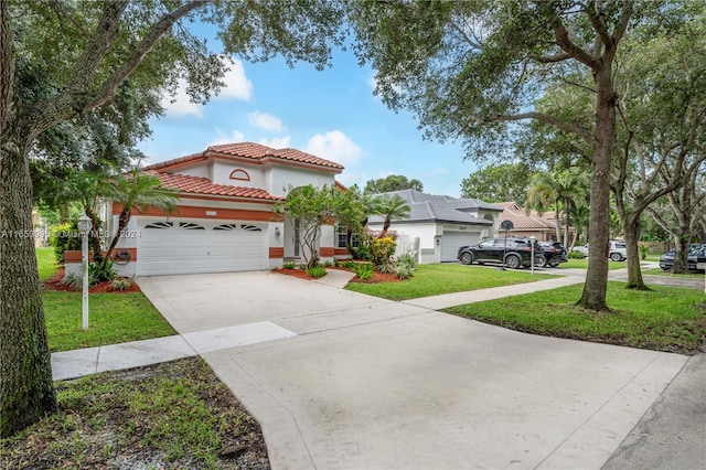 mediterranean / spanish home featuring a garage and a front lawn