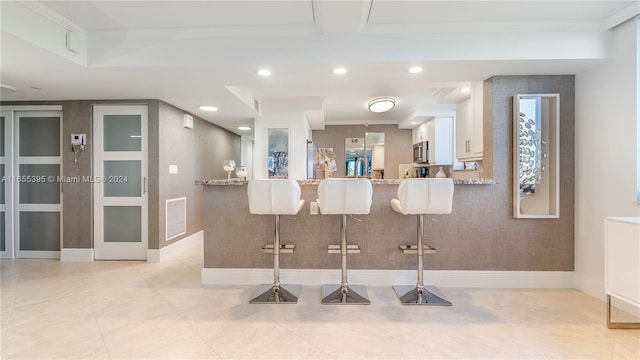 interior space featuring light stone countertops, appliances with stainless steel finishes, and white cabinetry