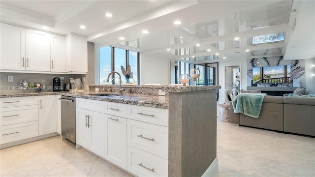 kitchen with light tile patterned floors, white cabinetry, kitchen peninsula, and sink