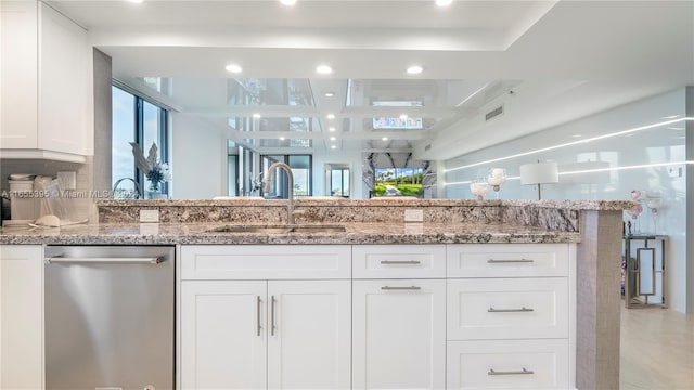 kitchen featuring dishwasher, white cabinets, sink, and light stone countertops