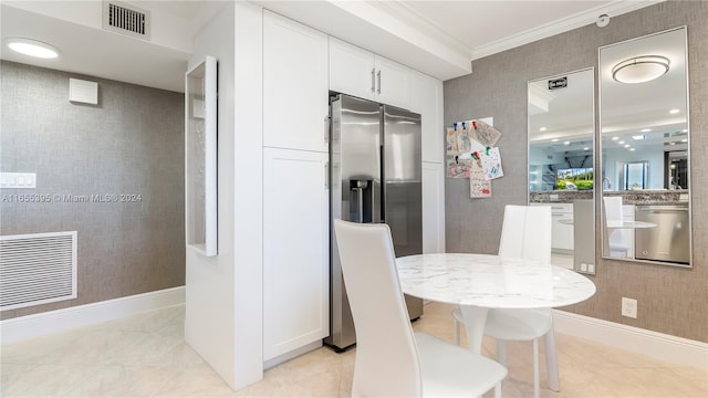 kitchen with crown molding, stainless steel appliances, light stone countertops, and white cabinetry